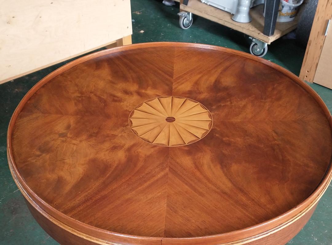 Sunburst-matched figured veneer table top with an inlaid fan patera, French polished