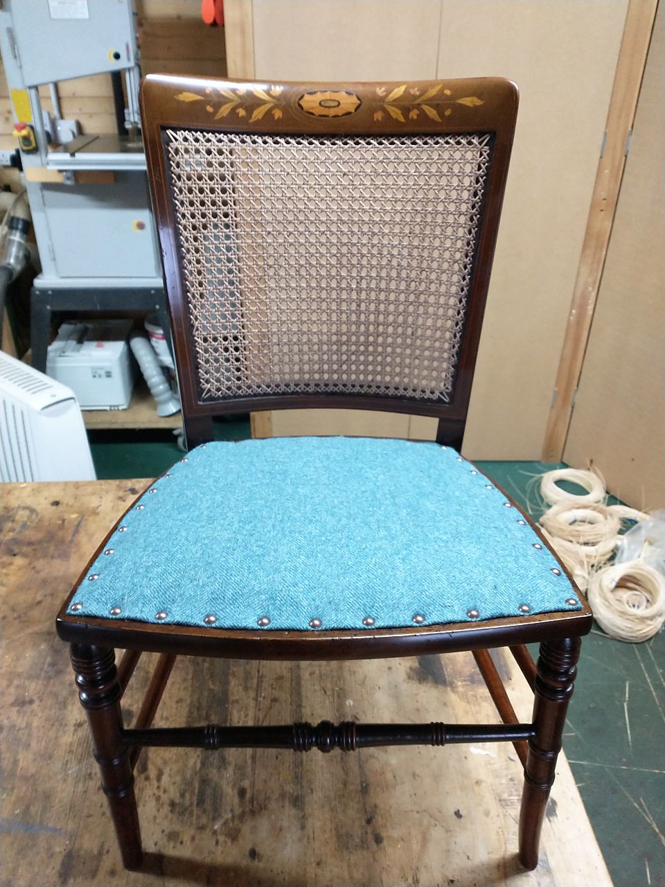 The same inlaid chair after: hand-woven cane back panel and a new studded turquoise seat